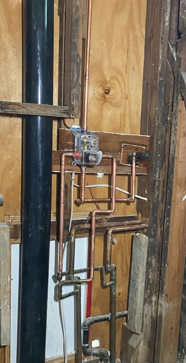 Copper repipe running through an open stud wall with a new pressure regulator
